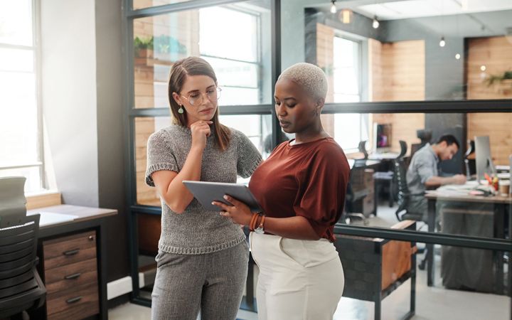 two colleagues looking at a tablet